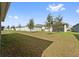 Spacious fenced backyard featuring a lush lawn, young trees, and ample space for outdoor activities and privacy at 6745 Huntleigh Hammock Rd, Harmony, FL 34773