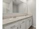 Bathroom featuring dual sinks, white cabinets, and a large mirror at 6745 Huntleigh Hammock Rd, Harmony, FL 34773