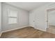 Bright bedroom with wood-look flooring, a window, and a closet door at 6745 Huntleigh Hammock Rd, Harmony, FL 34773