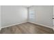 Clean, simple bedroom with window, wood floor, and white walls at 6745 Huntleigh Hammock Rd, Harmony, FL 34773