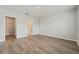 Spacious bedroom featuring wood-look flooring with adjacent walk-in closet and bathroom entries at 6745 Huntleigh Hammock Rd, Harmony, FL 34773