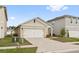 Single-story home featuring a two-car garage, neutral colors, and a well-manicured lawn at 6745 Huntleigh Hammock Rd, Harmony, FL 34773