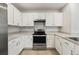 Bright kitchen with stainless steel stove and white cabinets at 6745 Huntleigh Hammock Rd, Harmony, FL 34773