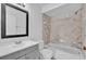 Bathroom featuring tiled shower over tub, neutral walls and gray vanity with modern hardware at 705 Northlake Dr # 705, Sanford, FL 32773