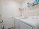 Laundry room features a white washer and dryer, storage shelf, and access door at 739 Annabell Ridge Rd, Minneola, FL 34715