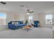 Spacious living room is furnished with comfortable blue couch and chair, ceiling fan and lots of light at 739 Annabell Ridge Rd, Minneola, FL 34715