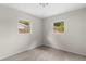 Small bedroom with two windows looking outside to lush trees and blue sky at 7427 Houston E Ct, Winter Park, FL 32792