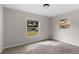 A modest bedroom featuring carpeted floors and two windows looking out to the neighborhood at 7427 Houston E Ct, Winter Park, FL 32792