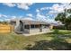 The backyard features a well-maintained lawn, a chimney, and a charming screened-in porch, perfect for relaxing at 8042 Tompkins Sq, Orlando, FL 32807