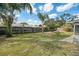 Spacious backyard featuring a wood fence, lush lawn, and mature palm trees, perfect for outdoor enjoyment at 8042 Tompkins Sq, Orlando, FL 32807