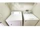 Compact laundry area with a white Amana dryer and a white Whirlpool washing machine at 8103 Lillies Way # 202, Orlando, FL 32825