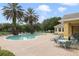 A kidney-shaped community pool is surrounded by tall palm trees and lounge chairs at 8103 Lillies Way # 202, Orlando, FL 32825