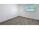 Empty bedroom featuring light gray wood-look floors, white walls, and a window at 850 Rosalia Dr, Sanford, FL 32771