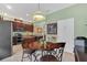 Warm dining area featuring a wooden table and chairs, adjacent to the kitchen with dark cabinetry at 9130 Sabal Pine Way, Orlando, FL 32832