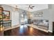 Stylish living room with hardwood floors, gray sofa, natural light, and smooth transition to dining at 9130 Sabal Pine Way, Orlando, FL 32832