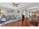 Open-concept living room with hardwood floors, gray sofa, and seamless flow to dining area at 9130 Sabal Pine Way, Orlando, FL 32832