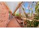 Covered balcony with brick walls, wood floors and metal railings looking out onto lush greenery at 127 Georgetown Dr # 127, Casselberry, FL 32707