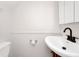 Powder room with a pedestal sink, modern black faucet, and a white toilet and walls at 127 Georgetown Dr # 127, Casselberry, FL 32707