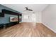 Open living room featuring wood-look floors, a ceiling fan, media center, and an opening to the hallway at 127 Georgetown Dr # 127, Casselberry, FL 32707