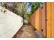 Narrow backyard walkway lined by a brick wall and wooden fence at 127 Georgetown Dr # 127, Casselberry, FL 32707