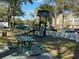 Community playground and picnic area with benches, trees, and nearby parking at 13028 Plantation Park Cir # 1218, Orlando, FL 32821