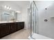 Bathroom showcasing dual vanities, modern lighting, and glass-enclosed shower with white tile at 13270 Panama Beach Ct, Orlando, FL 32827