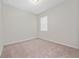 Bright bedroom featuring neutral carpet, a window providing natural light, and ample wall space at 13270 Panama Beach Ct, Orlando, FL 32827