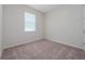 Bright bedroom featuring neutral carpet, a window providing natural light, and ample wall space at 13270 Panama Beach Ct, Orlando, FL 32827