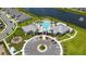 Aerial view of a community clubhouse featuring a pool, palm trees, plenty of parking, and a lake view at 13270 Panama Beach Ct, Orlando, FL 32827