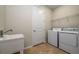 Functional laundry room featuring a utility sink, washer, dryer, and convenient storage shelving at 13270 Panama Beach Ct, Orlando, FL 32827