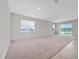 Spacious living room featuring neutral walls, carpet, and sliding glass doors for ample natural light at 13270 Panama Beach Ct, Orlando, FL 32827