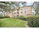 Exterior view of a multi-story condo building with well-manicured landscaping and a bright sky at 13500 Turtle Marsh Loop # 839, Orlando, FL 32837