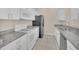 Galley kitchen featuring granite countertops, white cabinetry, and stainless steel appliances at 13500 Turtle Marsh Loop # 839, Orlando, FL 32837