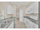 View of a bright kitchen with stainless steel appliances, granite countertops, and white cabinets at 13500 Turtle Marsh Loop # 839, Orlando, FL 32837