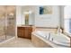 Bathroom featuring a glass shower, a soaking tub, and a decorative granite vanity at 1440 Pro Shop Ct, Davenport, FL 33896