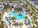 An aerial view shows a pool with lounge chairs and umbrellas surrounded by palm trees at 1440 Pro Shop Ct, Davenport, FL 33896