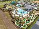 Aerial view of a community pool and water park with palm trees, mini golf, and a playground at 1440 Pro Shop Ct, Davenport, FL 33896