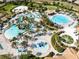 Aerial view of a large community pool and water park with palm trees and lounge chairs at 1440 Pro Shop Ct, Davenport, FL 33896