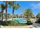 Beautiful community pool area with mature palm trees, lounge seating, and sun umbrellas at 1440 Pro Shop Ct, Davenport, FL 33896