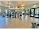 Well-equipped gym with machines, free weights, mirrors and windows bringing in natural light at 1440 Pro Shop Ct, Davenport, FL 33896