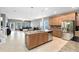 Open-concept kitchen with island, stainless steel appliances, seamlessly connected to a living area with large windows and neutral tones at 1440 Pro Shop Ct, Davenport, FL 33896