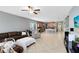 Bright and airy living room flowing into the kitchen, featuring comfortable seating, tile floors, and a modern open layout at 1440 Pro Shop Ct, Davenport, FL 33896