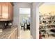 View from kitchen into the dining room and walk-in pantry, complete with shelving units to maximize storage and organization at 1440 Pro Shop Ct, Davenport, FL 33896