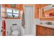 Bright bathroom with orange walls, white tile and decorative beach-themed accents throughout at 1461 Helena Ct, Deltona, FL 32725