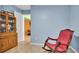 Sitting room with a red rocking chair and antique cabinet looking through a doorway to other rooms at 1461 Helena Ct, Deltona, FL 32725