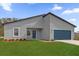 Charming single-story home featuring a blue garage door, lush green lawn, and modern architectural design at 14889 Sw 46Th Ct, Ocala, FL 34473