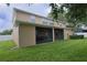 The home's backyard featuring a screened-in porch, healthy green grass, and partial shade at 15313 Hayworth Dr, Winter Garden, FL 34787