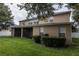 View of the backyard, featuring a screened-in porch, healthy green grass, and partial shade at 15313 Hayworth Dr, Winter Garden, FL 34787