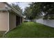 A view of the home's lawn, featuring a screened-in porch and a white fence at the property line at 15313 Hayworth Dr, Winter Garden, FL 34787