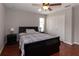 Cozy bedroom featuring a black bed frame, wood floors, and a ceiling fan at 15313 Hayworth Dr, Winter Garden, FL 34787
